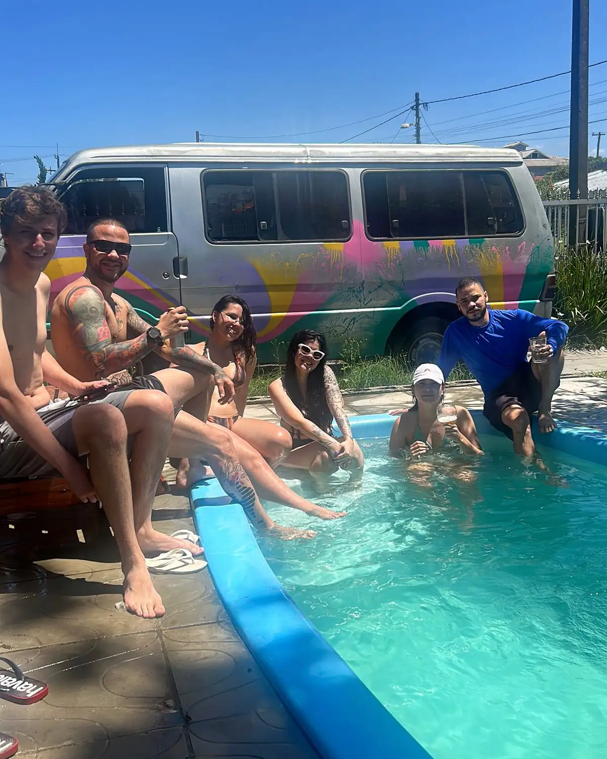 Moradores em volta da piscina num dia de sol