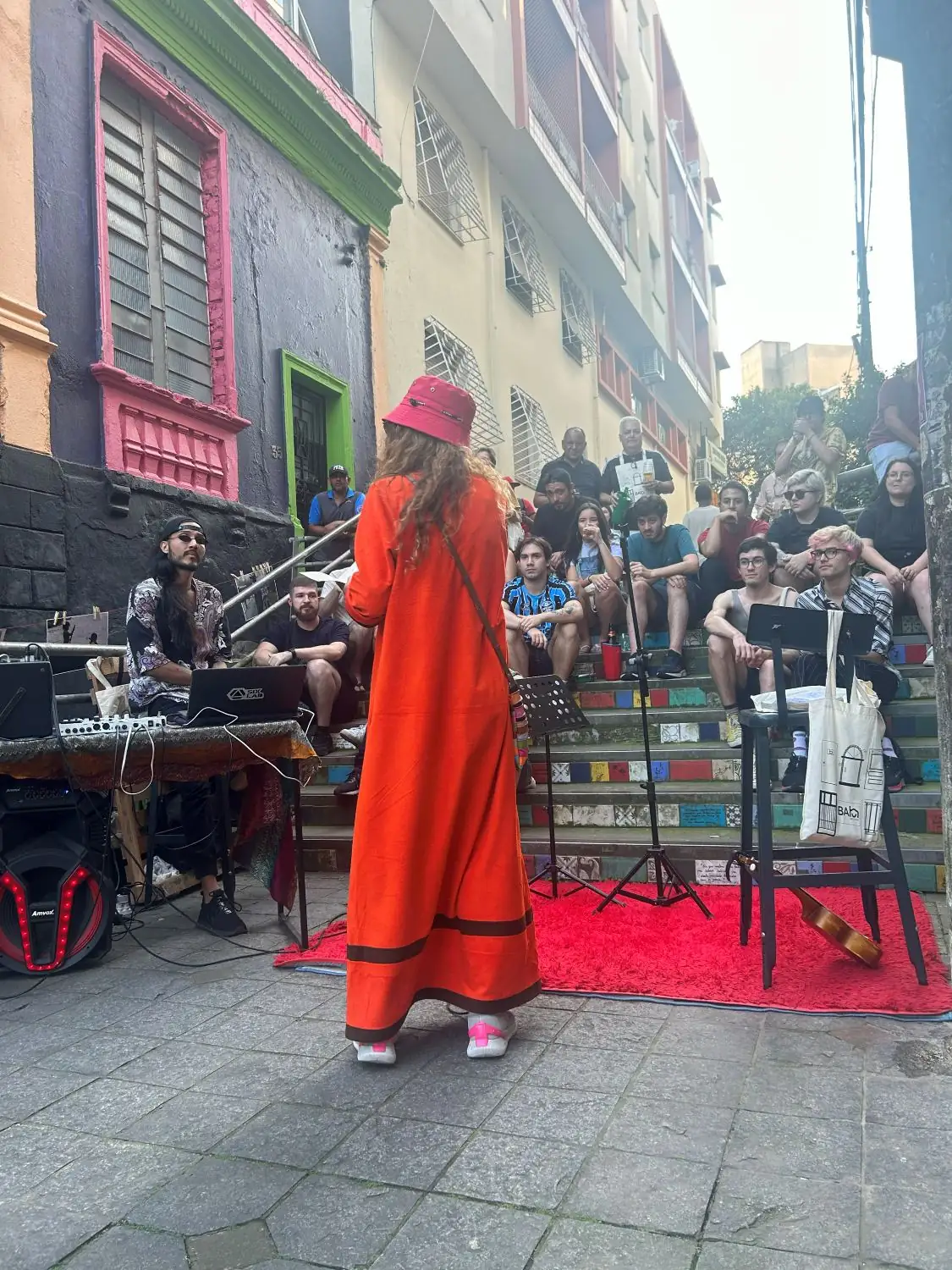 Apresentação musical na escadaria, com plateia sentada nos degraus